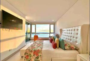 a bedroom with a large bed and a television at Large 3BR Apt with beautiful ocean views in Cartagena de Indias