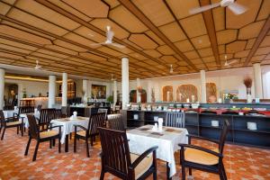 a dining room with tables and chairs in a restaurant at Le Aqua Resort & Spa Phan Thiet - Swiss Village Resort & Spa in Mui Ne
