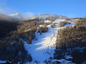 eine Gruppe von Menschen, die einen schneebedeckten Berg hinunterfahren in der Unterkunft Studio proche pistes Chantemerle in Saint-Chaffrey