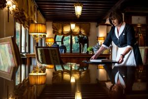 Eine Frau, die vor einem Tisch mit einem Laptop steht. in der Unterkunft Relais et Châteaux Hotel Villa Franceschi in Mira