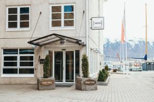 a building with a door with potted plants in front of it at Home Hotel With in Tromsø