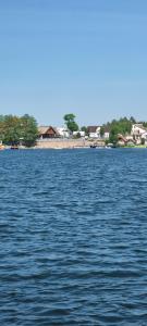 a large body of water with a beach in the background at Ramlejowe Wzgórze - Sauna-Balia in Ostrzyce