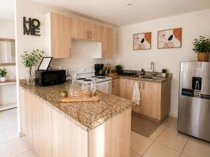 a kitchen with wooden cabinets and a stainless steel refrigerator at Apto Deluxe, 3 hab, piscina y rooftop en Escalón in San Salvador