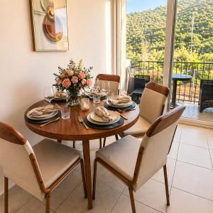 a dining room table with chairs and a table with flowers on it at Apto Deluxe, 3 hab, piscina y rooftop en Escalón in San Salvador