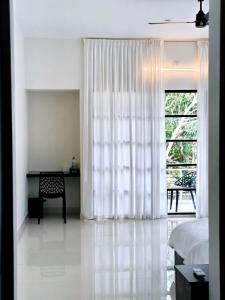 a bedroom with a bed and a desk and a window at Myday Inn by Znormhomes in Varkala