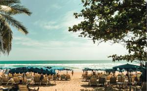 a beach with chairs and umbrellas and the ocean at Sugar Marina Hotel - ART - Karon Beach in Karon Beach +17 photos