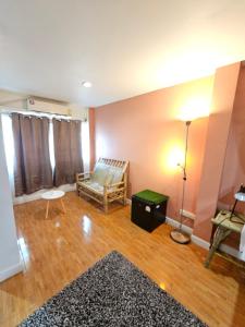 a living room with a couch and a table at Papa house red room in Pak Kret
