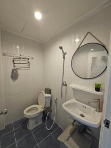 a bathroom with a toilet and a sink and a mirror at Papa house red room in Pak Kret