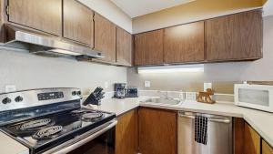 a kitchen with a stove and a microwave at Crystal Beach Condo - Lake Views & Pool in McCall