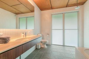 a bathroom with a sink and a toilet and a window at Dune Ten in Fingal Head