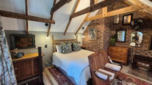 a bedroom with a bed and a tv in a room at Lacebark Cottage in Hilton