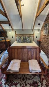 a bedroom with a wooden bed with two towels on it at Lacebark Cottage in Hilton