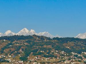 a town on a hill with mountains in the background at Hotel Dachi Kathmandu - Bhaktapur in Bhaktapur