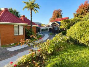 a garden with a house and a palm tree at Pure Motel in Rotorua