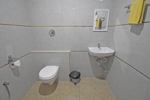 a small bathroom with a toilet and a sink at Hotel De Lux Splendid in Pondicherry