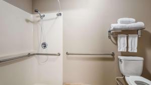 a bathroom with a shower and a toilet with towels at Best Western Oak Meadows Inn in Saint Helens +6 photos