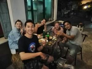 a group of people sitting around a table at 4Hearts Hotel in Suratthani