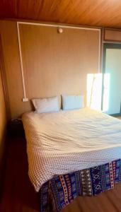 a bed with two pillows on it in a room at Hostel 405 Sa Pa in Sapa +1 photo