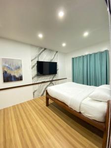 a bedroom with a bed and a flat screen tv at Marqis Sunrise Sunset Resort and Spa in Baclayon