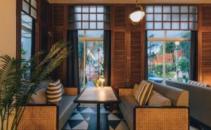 a room with a couch and a table and windows at Sugar Marina Hotel - NAUTICAL - Kata Beach in Kata Beach