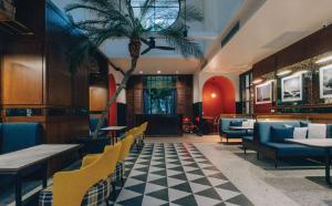 a restaurant with a palm tree in the middle of a room at Sugar Marina Hotel - NAUTICAL - Kata Beach in Kata Beach