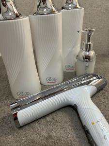 a white toothbrush sitting next to three toothbrushes at Coucou! in Takasaki