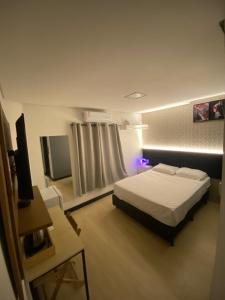 a bedroom with a bed and a tv in it at Smart Hotel Joinville in Joinville