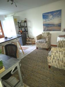 a living room with two chairs and a table at At Lilac Cottage, Jeffreys Bay Cozy stay for 2 & Business traveling in Jeffreys Bay