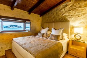 a bedroom with a large bed and a large window at Exensian Villas & Suites in Marathias