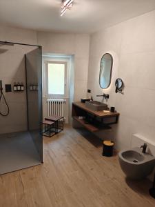 a bathroom with a sink and a toilet and a mirror at Hotel Emiliana in Villadossola +66 photos
