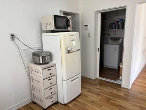 ein weißer Kühlschrank mit einer Mikrowelle darauf in der Unterkunft TomoHouse in Kutchan