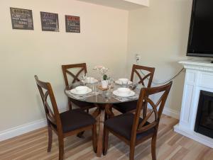 a dining room with a table and chairs and a fireplace at Modern, private & luxurious executive suite in Delta