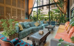 a living room with a couch and tables and plants at Sugar Marina Hotel-SURF-Kata Beach in Kata Beach