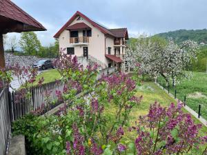 a house with flowers in front of a fence at La Ograda in Ponoarele
