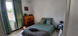 a bedroom with a bed and a chair and a window at La maisonnette in Cléry-Saint-André