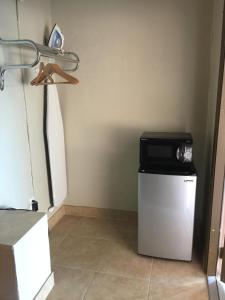 einen kleinen Kühlschrank mit einer Mikrowelle darüber in der Unterkunft Campbell Motel in Cocoa
