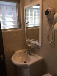 a bathroom with a sink and a mirror at Campbell Motel in Cocoa