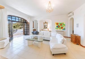 a living room with a white couch and a table at Villa Marecoco in Forio d'Ischia