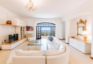 a living room with a white couch and a tv at Villa Marecoco in Forio d'Ischia
