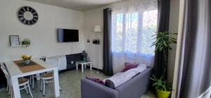 a living room with a couch and a table at La maisonnette in Cléry-Saint-André