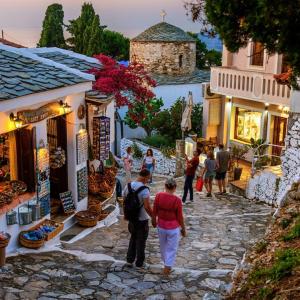 a group of people walking down a stone street at Julia's Home in Patitiri