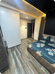 a bedroom with a blue bed and a wooden floor at EVARA- Swaminarayan enclave in Nagpur