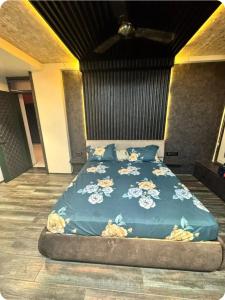 a bed with a blue comforter with flowers on it at EVARA- Swaminarayan enclave in Nagpur