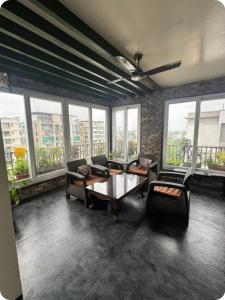 a living room with a table and chairs and windows at EVARA- Swaminarayan enclave in Nagpur