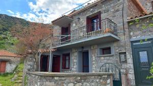 a stone house with a balcony and a door at Serafima's house Lesvos in Sykaminéa +18 photos