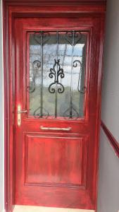a red door with a window in a room at Serafima's house Lesvos in Sykaminéa