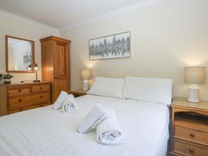 a bedroom with a white bed with towels on it at Chestnut Timber Lodge in Keswick