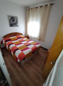 a bedroom with a bed with a checkered blanket at Enjoy Pirineos in Huesca