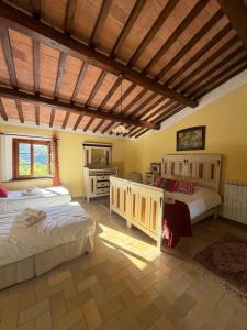 a bedroom with two beds and a wooden ceiling at Casa nel bosco il Grottone in Montaione