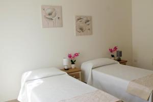 two beds in a room with flowers on the wall at B&B Le Orchidee in Alghero